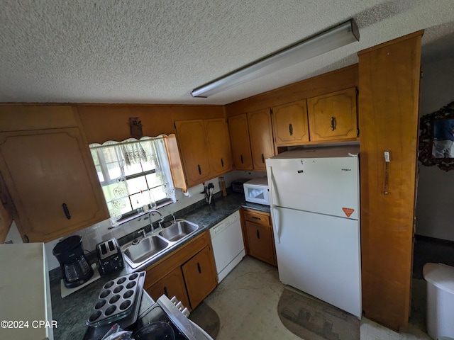 kitchen featuring a textured ceiling, white appliances, and sink