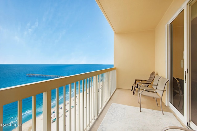 balcony featuring a water view and a view of the beach