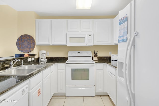 kitchen featuring sink, light tile patterned floors, dark stone counters, white appliances, and white cabinets