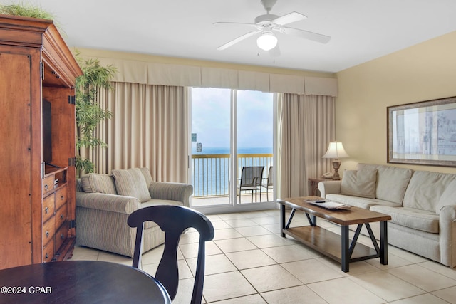 tiled living room featuring a water view and ceiling fan