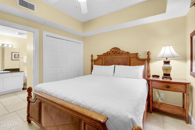 bedroom with connected bathroom, ceiling fan, a closet, and light tile patterned flooring