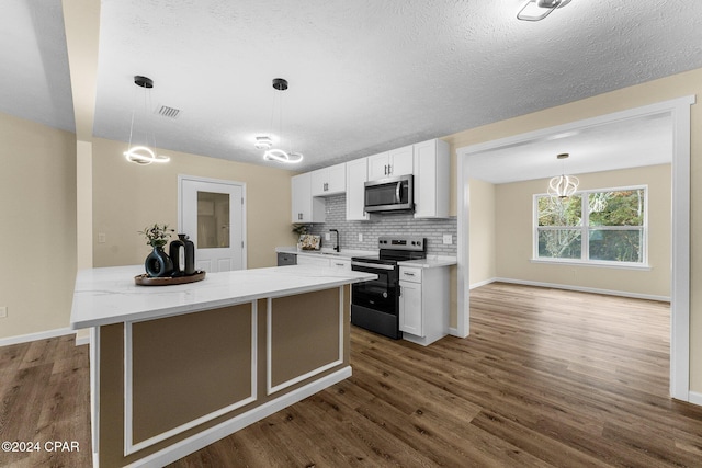 736 E Pine Forest Dr, Lynn Haven, FL 32444 - kitchen with stainless steel appliances, white cabinetry, dark wood finished floors, a center island, and a textured ceiling