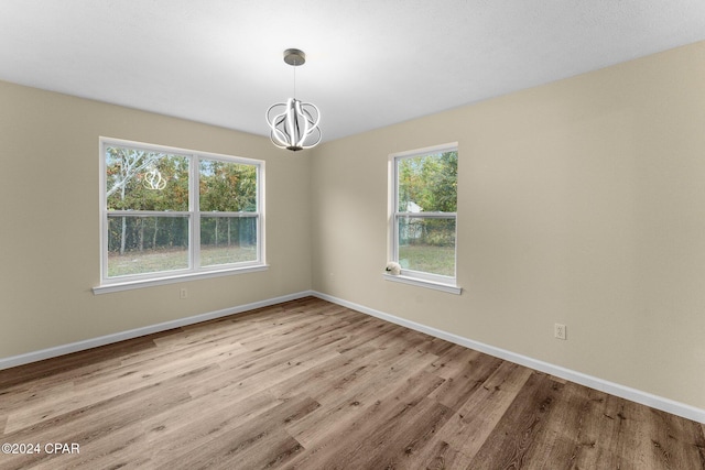 736 E Pine Forest Dr, Lynn Haven, FL 32444 - unfurnished room with a chandelier, wood finished floors, plenty of natural light, and baseboards