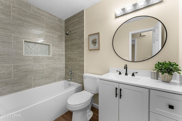 full bathroom with vanity, tiled shower / bath, toilet, a textured ceiling, and wood-type flooring