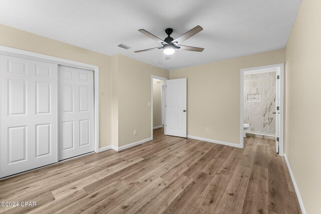 736 E Pine Forest Dr, Lynn Haven, FL 32444 - unfurnished bedroom with wood finished floors, a closet, baseboards, ensuite bath, and ceiling fan