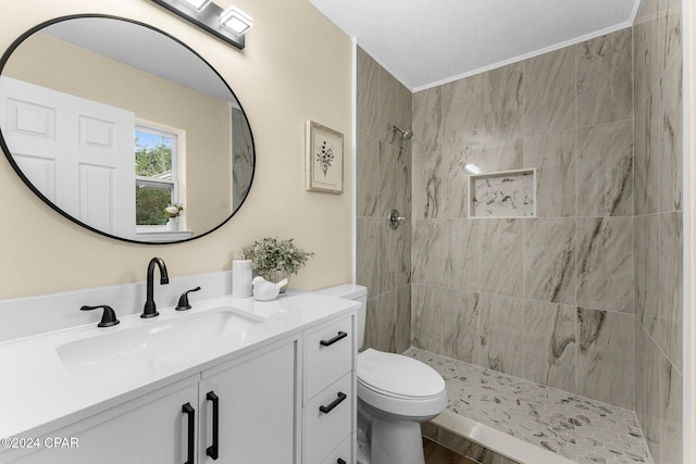 bathroom featuring a tile shower, vanity, a textured ceiling, hardwood / wood-style floors, and toilet