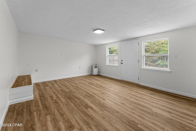 empty room with hardwood / wood-style floors and a textured ceiling