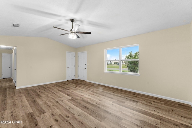 unfurnished room with vaulted ceiling, light hardwood / wood-style flooring, and ceiling fan