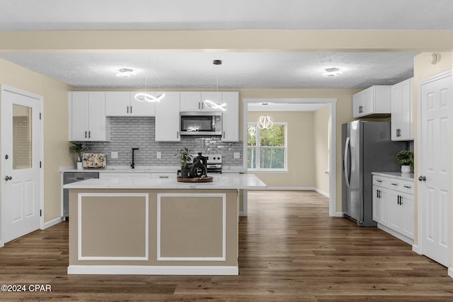 kitchen with white cabinetry, a center island, hanging light fixtures, and appliances with stainless steel finishes