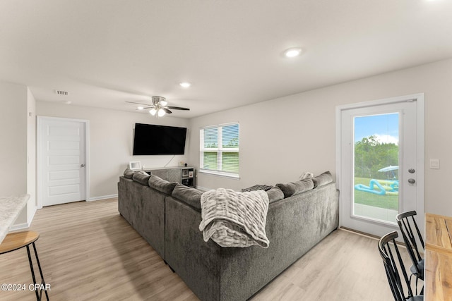 living room with light hardwood / wood-style flooring, plenty of natural light, and ceiling fan