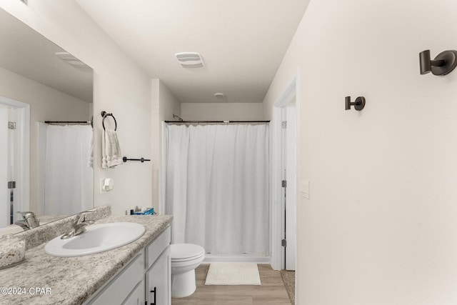 bathroom with hardwood / wood-style floors, vanity, toilet, and a shower with shower curtain