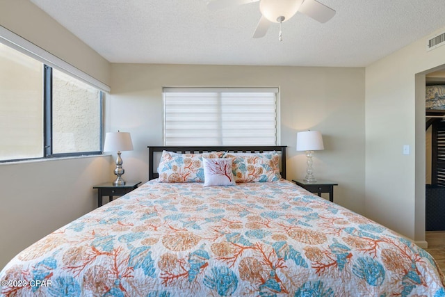 bedroom with a textured ceiling and a ceiling fan