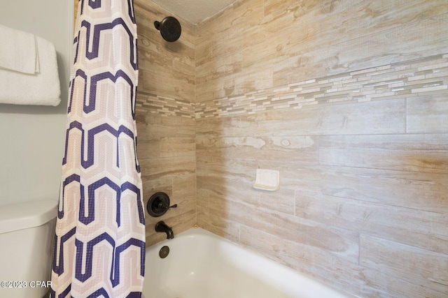 bathroom featuring shower / bath combo with shower curtain and toilet