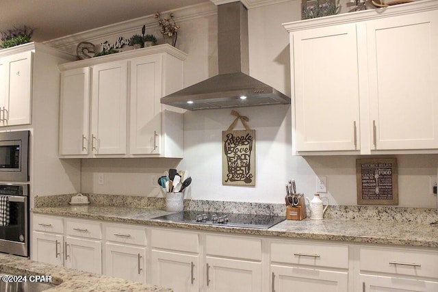 kitchen with wall chimney exhaust hood, light stone countertops, ornamental molding, appliances with stainless steel finishes, and white cabinetry