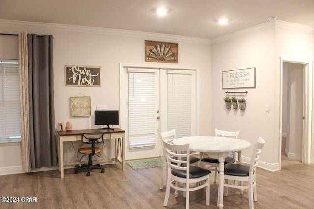 dining area featuring wood-type flooring and crown molding