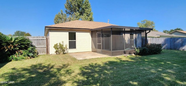 back of property featuring a sunroom and a lawn