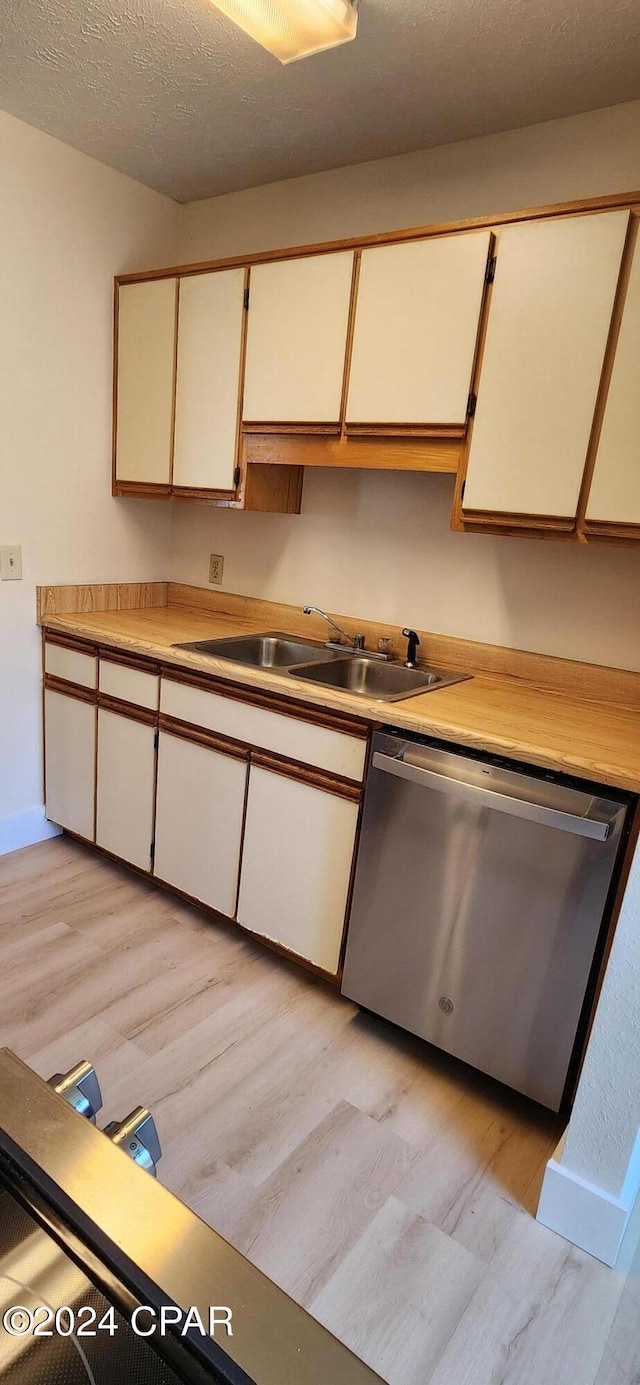 kitchen featuring dishwasher, white cabinets, and light wood-type flooring