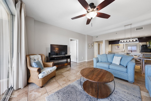 tiled living room featuring a healthy amount of sunlight and ceiling fan