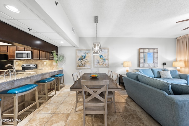 dining room featuring a textured ceiling and sink