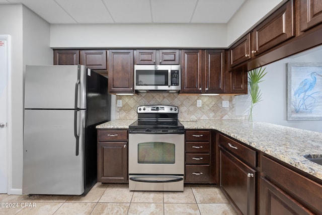 kitchen featuring dark brown cabinetry, appliances with stainless steel finishes, and light tile patterned floors