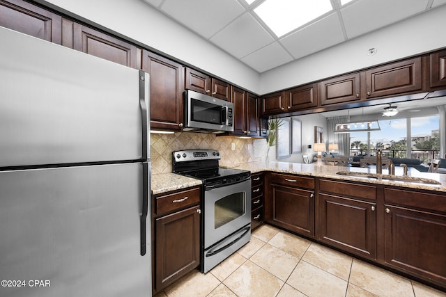 kitchen featuring dark brown cabinetry, a paneled ceiling, sink, appliances with stainless steel finishes, and light tile patterned floors