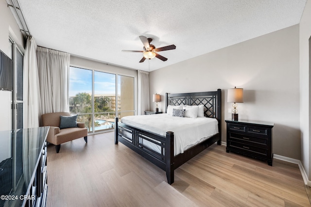 bedroom with access to outside, light wood-type flooring, a textured ceiling, and ceiling fan