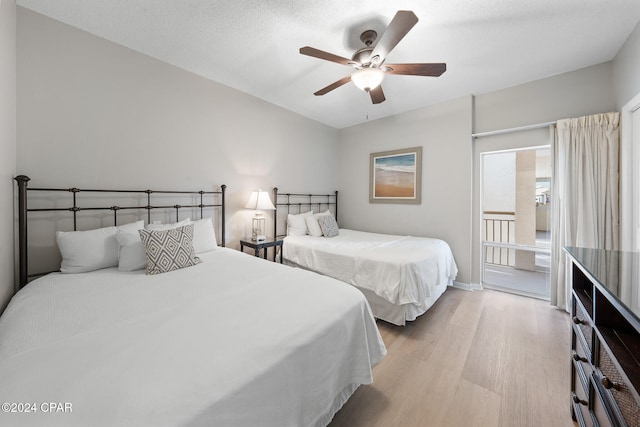 bedroom featuring light hardwood / wood-style floors, a textured ceiling, and ceiling fan