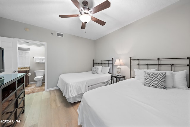 bedroom with ensuite bathroom, ceiling fan, and light wood-type flooring