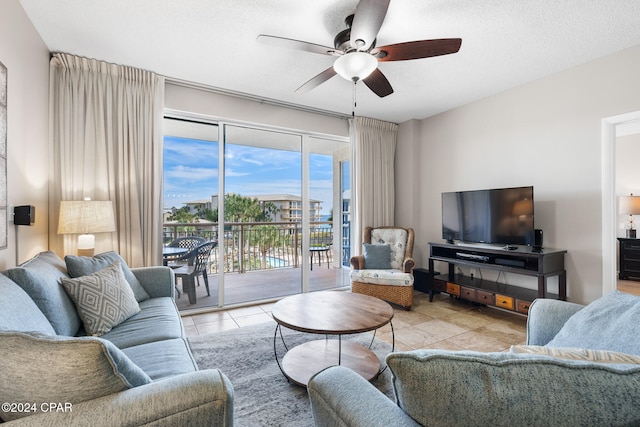 living room featuring light tile patterned flooring, a textured ceiling, and ceiling fan