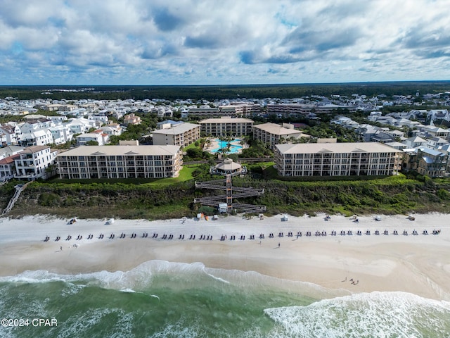 birds eye view of property with a water view and a beach view