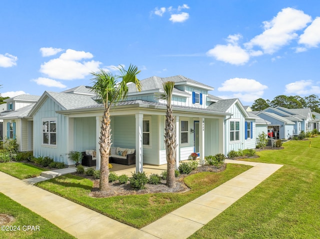 view of front of property featuring a porch, a front yard, and an outdoor hangout area