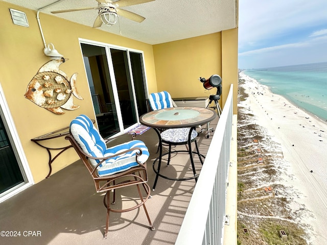 balcony with ceiling fan, a water view, and a beach view