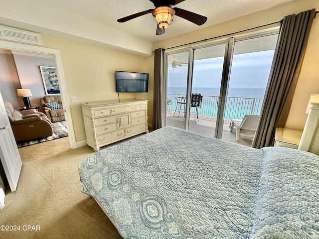 carpeted bedroom featuring ceiling fan, a textured ceiling, and access to exterior