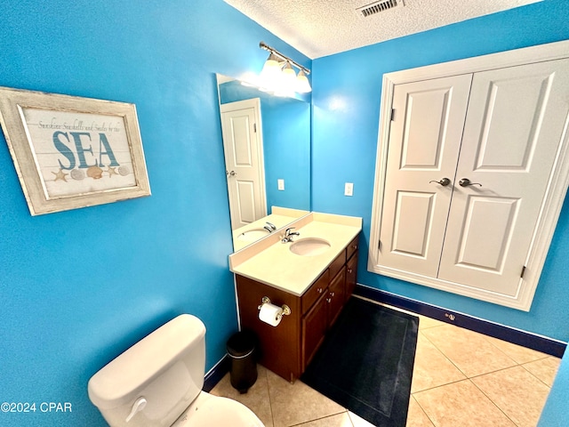 bathroom with vanity, a textured ceiling, toilet, and tile patterned floors