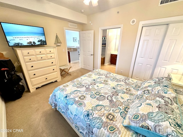 bedroom featuring connected bathroom, a textured ceiling, light colored carpet, and a closet