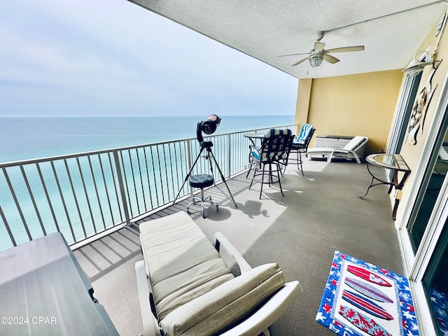 balcony featuring a water view and ceiling fan