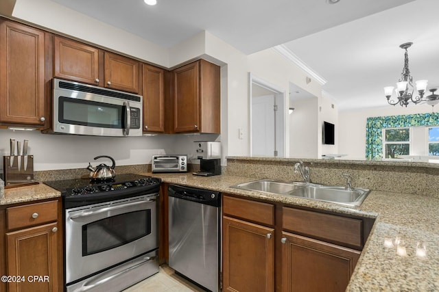 kitchen featuring brown cabinetry, a sink, a notable chandelier, and stainless steel appliances