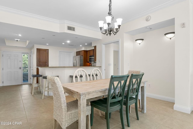 tiled dining area featuring crown molding and an inviting chandelier