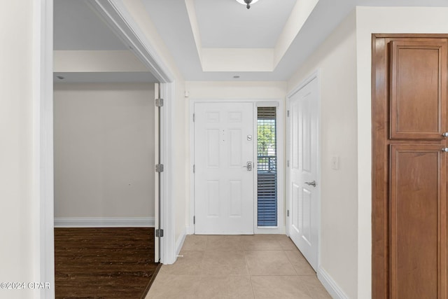 foyer entrance featuring a tray ceiling and light hardwood / wood-style floors