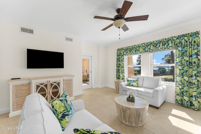 living room with visible vents, light tile patterned floors, baseboards, ornamental molding, and ceiling fan