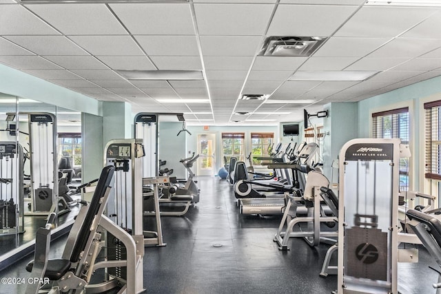 workout area with a paneled ceiling and plenty of natural light