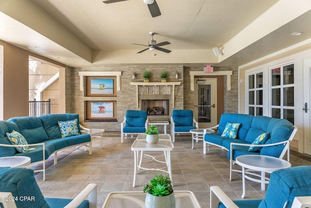 view of patio / terrace with an outdoor living space with a fireplace and ceiling fan