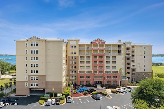 view of property with a water view and uncovered parking