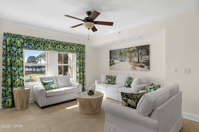 living area with crown molding, light tile patterned floors, baseboards, and a ceiling fan