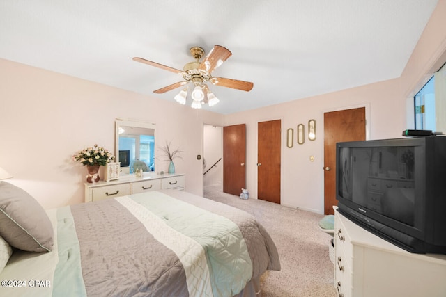 carpeted bedroom with ceiling fan and multiple windows