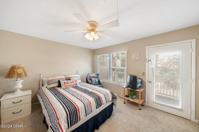 bedroom featuring light carpet, a textured ceiling, and ceiling fan