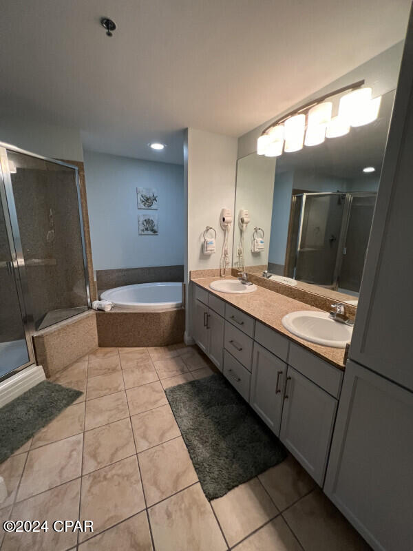 bathroom with tile patterned flooring, vanity, and shower with separate bathtub