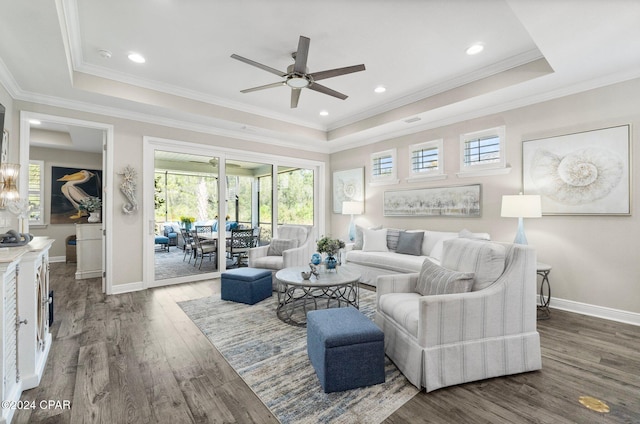 living room featuring ornamental molding, hardwood / wood-style flooring, ceiling fan, and a tray ceiling