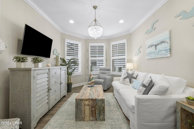 living room featuring hardwood / wood-style floors, ornamental molding, and an inviting chandelier