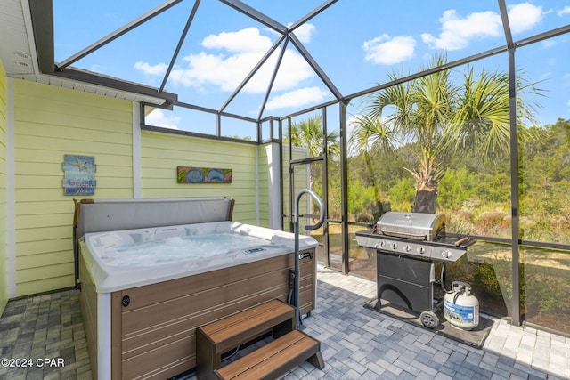 view of patio / terrace featuring glass enclosure, a hot tub, and grilling area